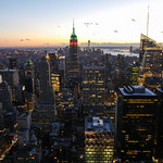 New York City skyline with the sun going down and the empire tower and all of the building that are lighting up nearby